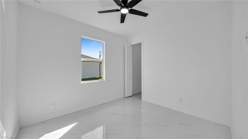 Empty room with light marble finish flooring and ceiling fan