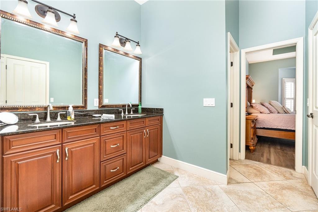 Ensuite bathroom with double vanity and light tile patterned floors