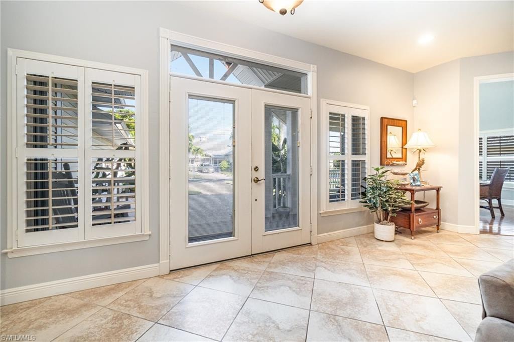 Entrance foyer with baseboards and light tile patterned floors