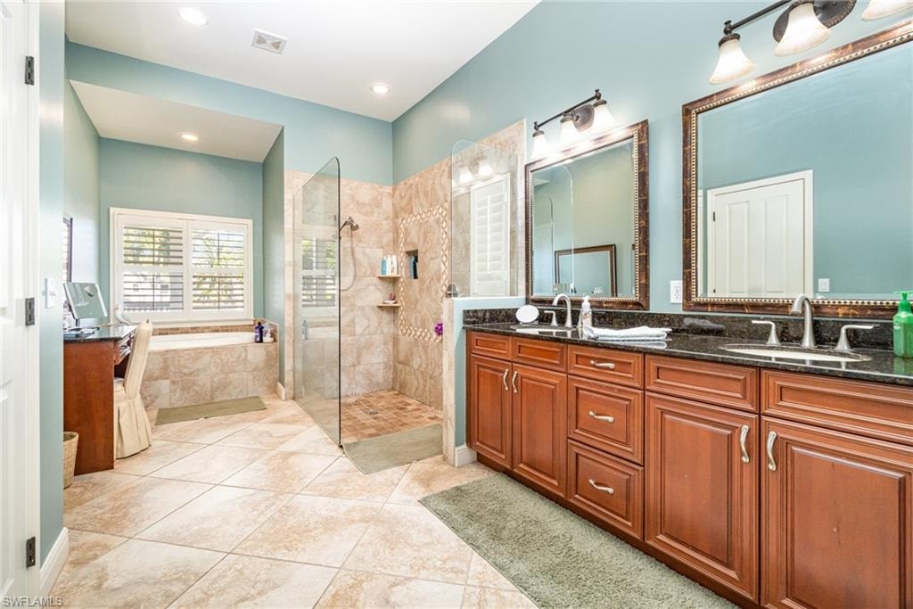 Bathroom featuring double vanity, light tile patterned flooring, a bath, a walk in shower, and recessed lighting