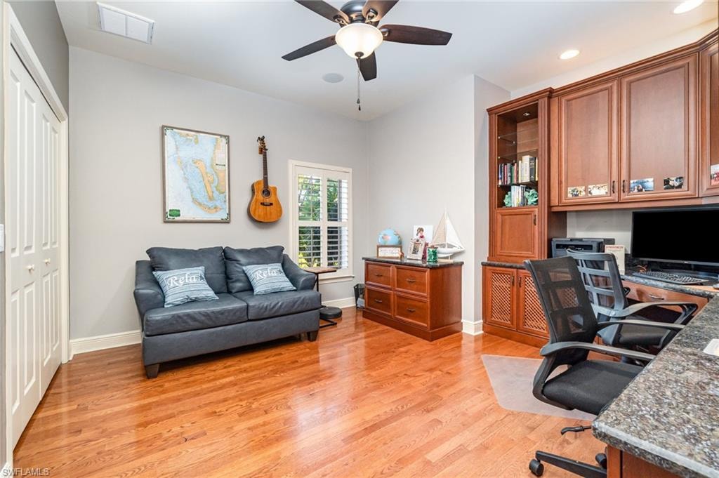 Office area with light wood-style flooring, a ceiling fan, built in desk, and recessed lighting