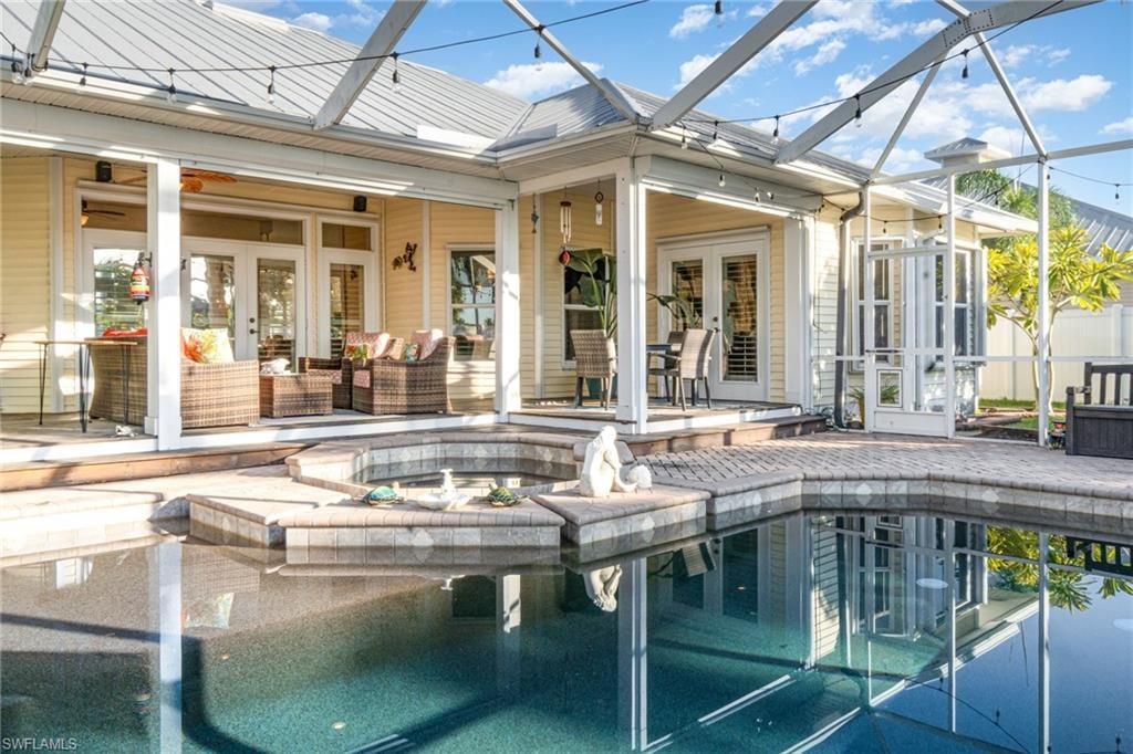 Back of house featuring french doors, a sunroom, a lanai, and a patio area