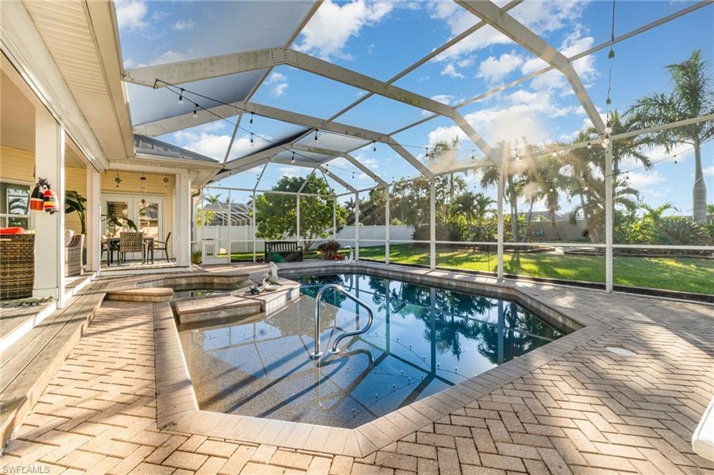 View of swimming pool featuring glass enclosure, a patio, a sunroom, and a pool with connected hot tub