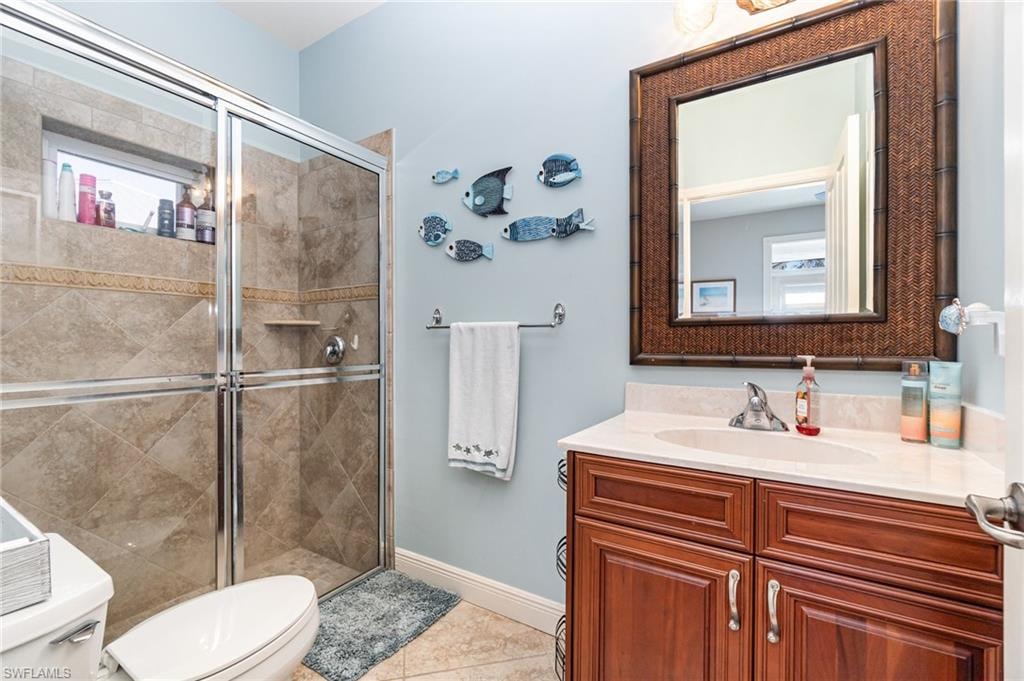 Full bathroom featuring vanity, a stall shower, and light tile patterned floors