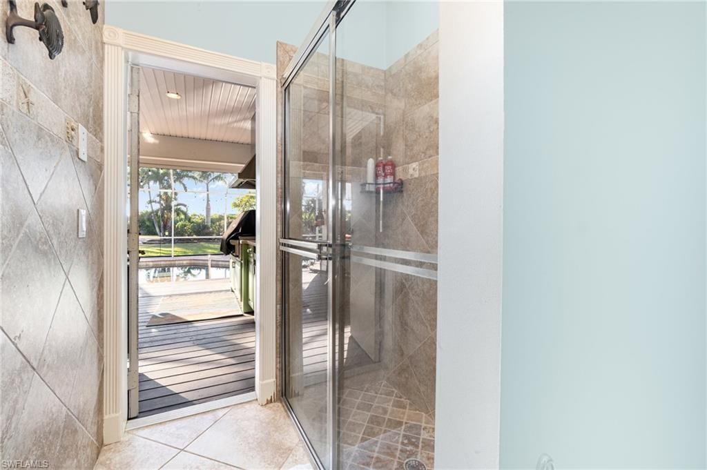 Bathroom featuring a shower stall and light tile patterned floors