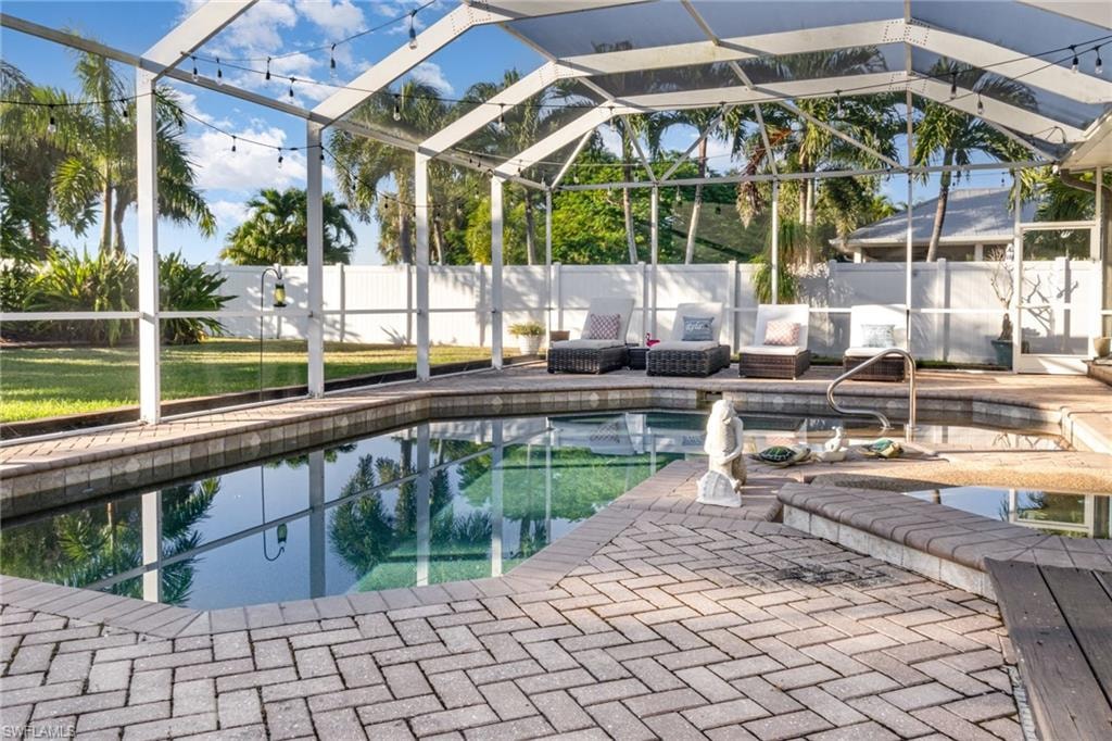 View of swimming pool with a fenced backyard, glass enclosure, a sunroom, and a patio area
