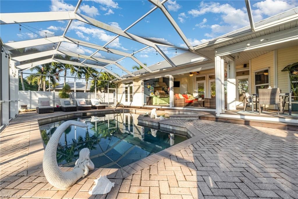 View of pool with an outdoor living space, a lanai, a patio area, and a sunroom