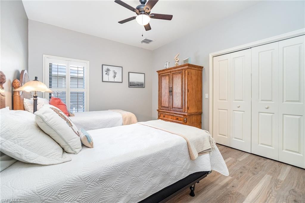 Bedroom featuring light wood-style floors, a closet, and a ceiling fan
