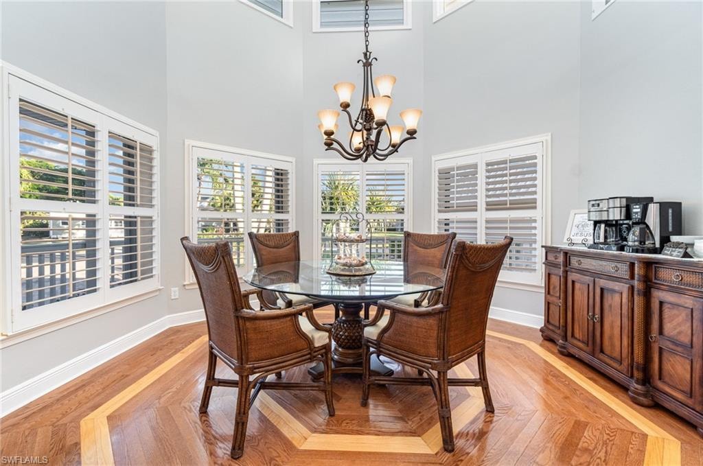 Dining space featuring a high ceiling, a chandelier, and parquet flooring