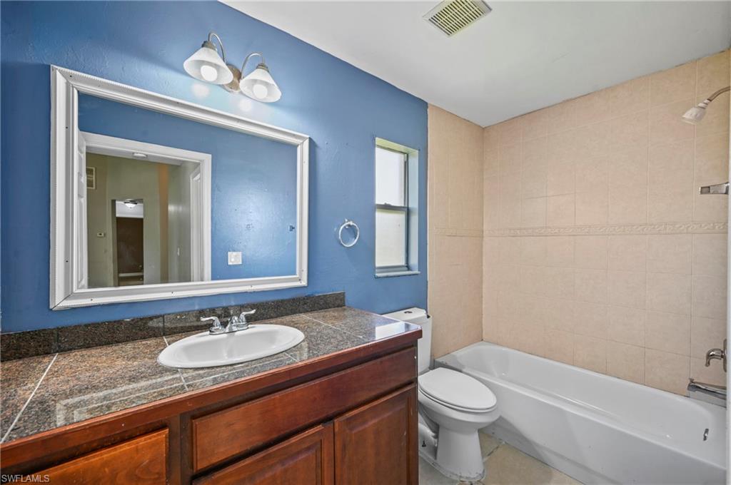 Full bath featuring  shower combination, vanity, and tile patterned floors