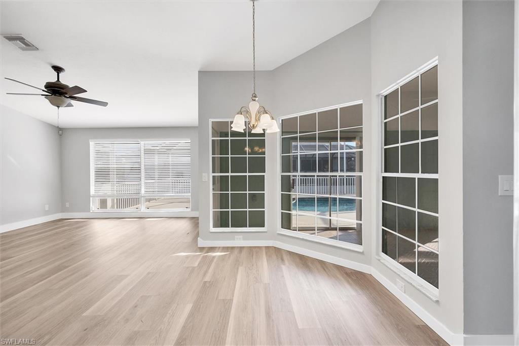 Unfurnished dining area with a chandelier, light wood-type flooring, and a ceiling fan