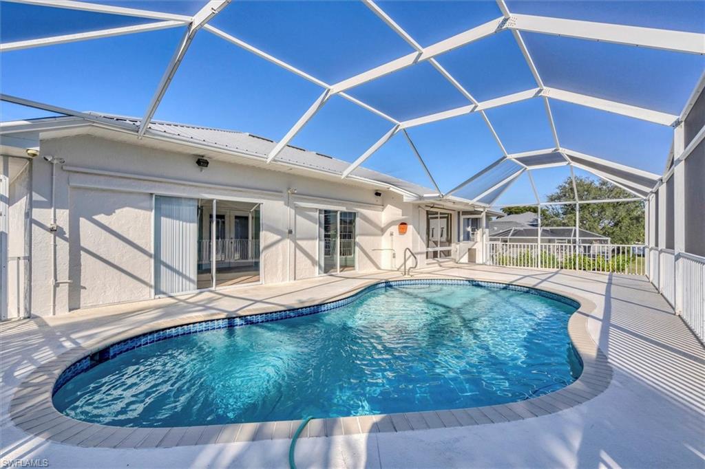 View of swimming pool featuring a sunroom, a lanai, and a patio area