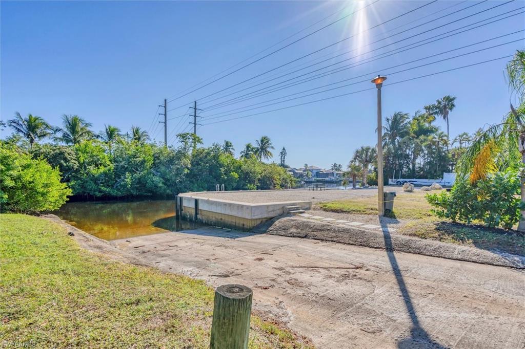 View of community featuring a boat ramp, a water view, and a dock