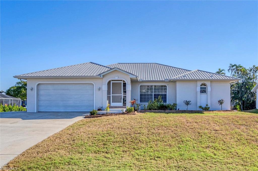 Ranch-style home with stucco siding, a front yard, driveway, and an attached garage