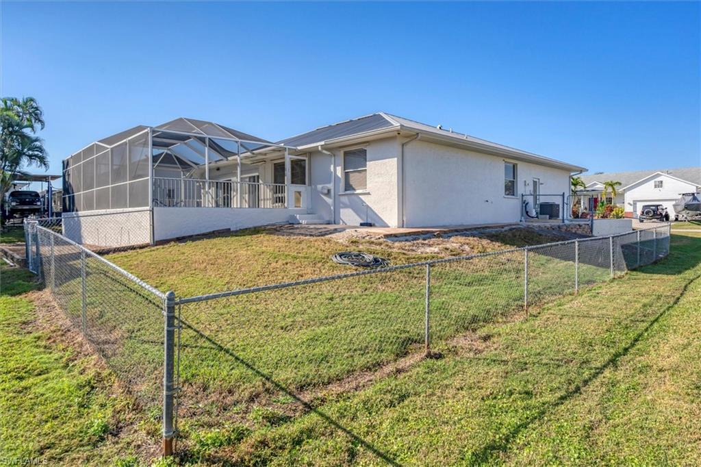 Back of property with a sunroom, a fenced backyard, glass enclosure, and stucco siding