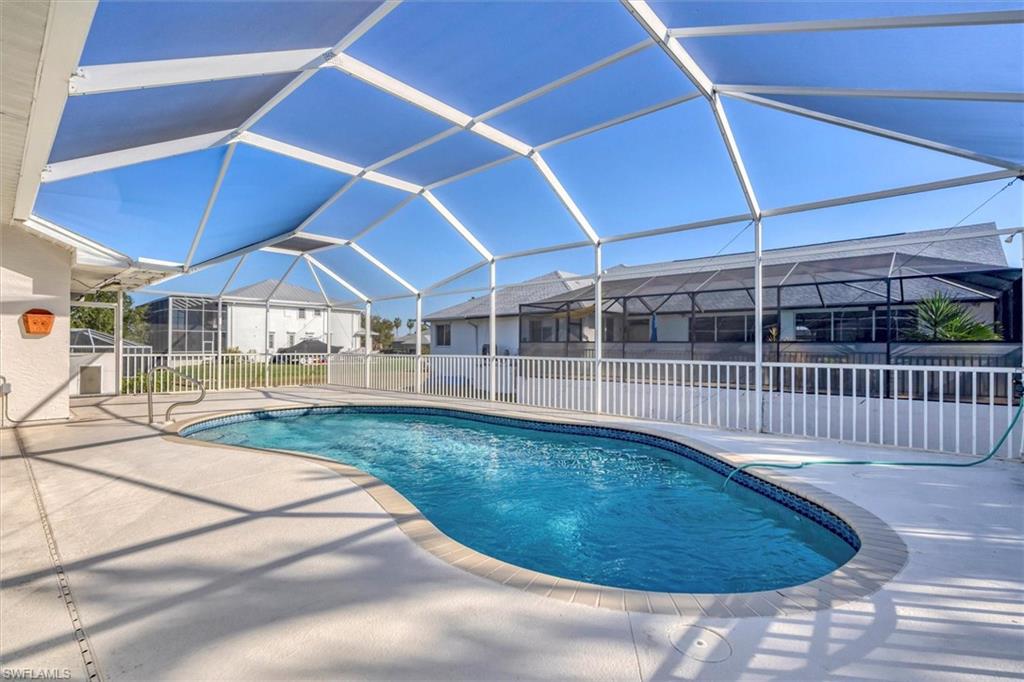 Swimming pool with glass enclosure, a sunroom, and a patio area