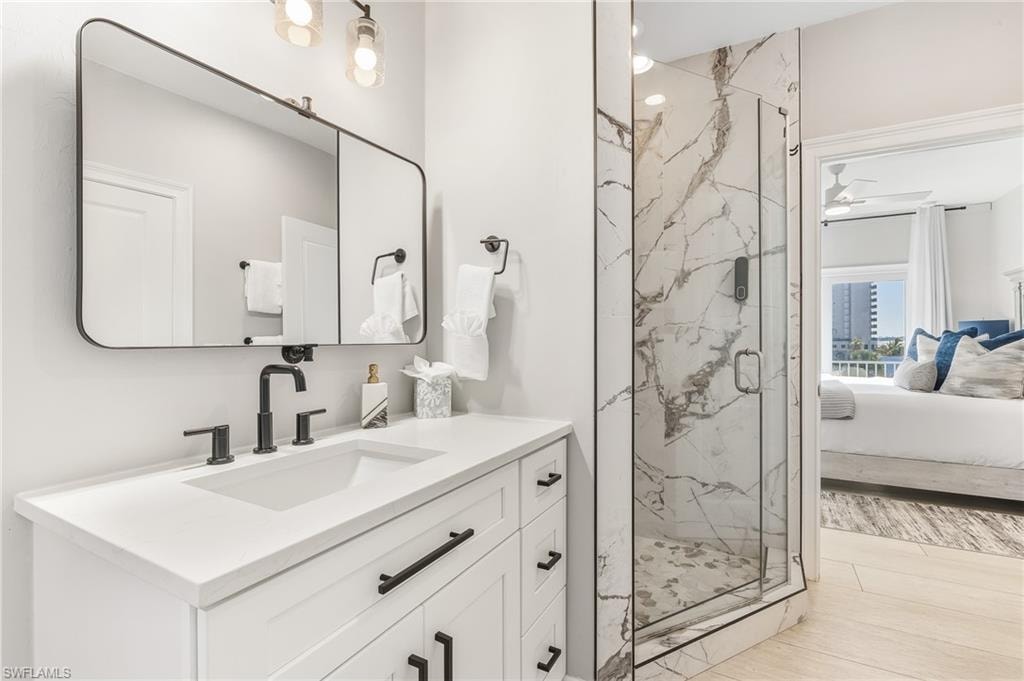 Ensuite bathroom featuring vanity and a marble finish shower