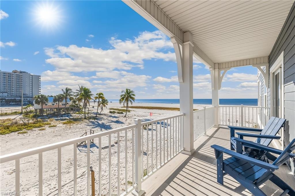 Balcony featuring view of water and beach