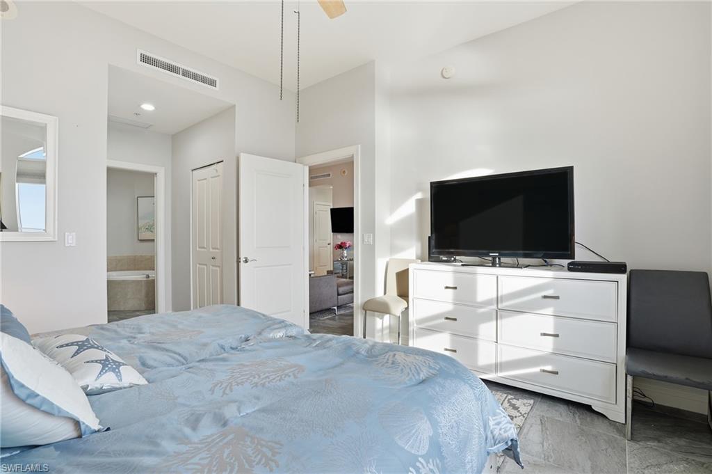 Bedroom featuring a closet, connected bathroom, and ceiling fan - Virtually Edited Image