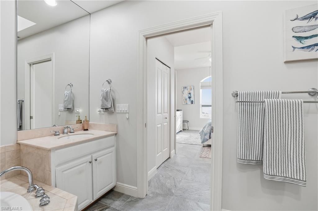 Ensuite bathroom with vanity, a bath, and a closet - Virtually Edited Image