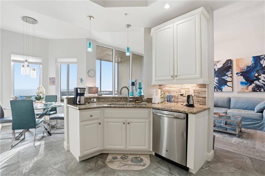 Kitchen featuring white cabinets, pendant lighting, decorative backsplash, dishwasher, and recessed lighting - Virtually Edited Image