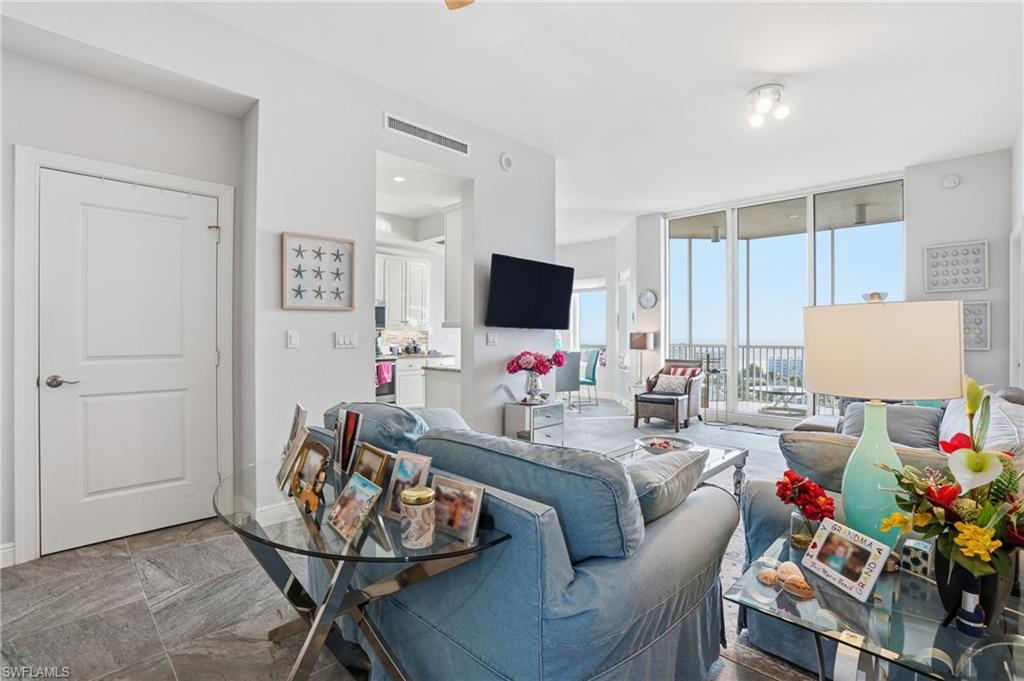 Living room featuring expansive windows and tile flooring - Virtually Edited Image