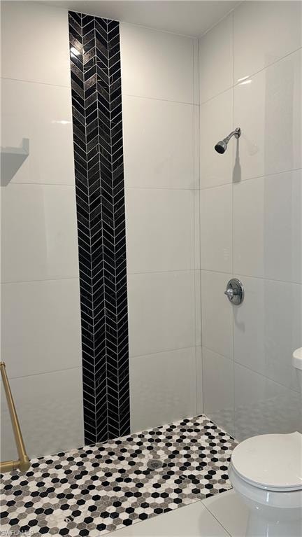 Bathroom with a shower stall and toilet