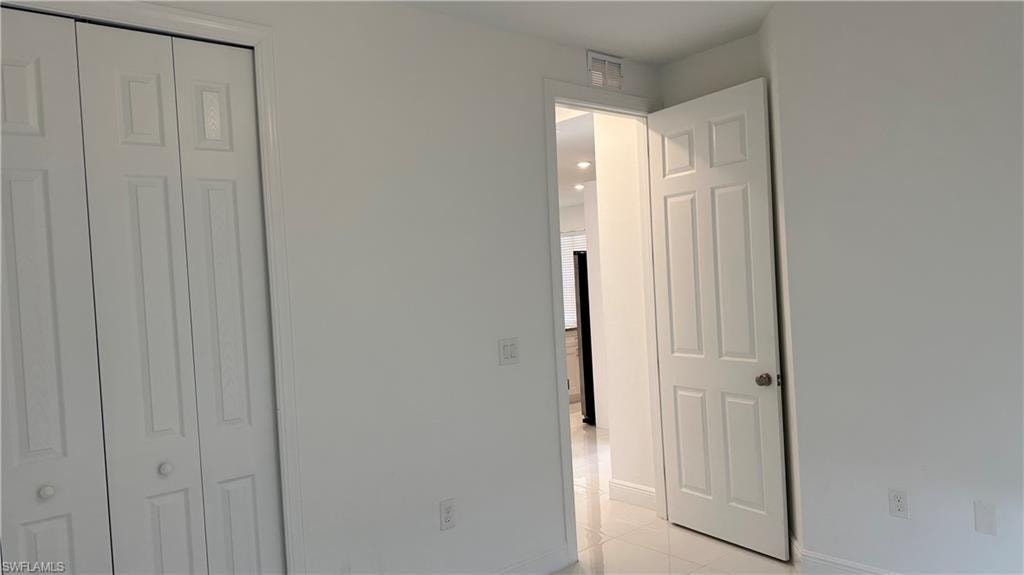 Unfurnished bedroom with a closet and light tile patterned floors
