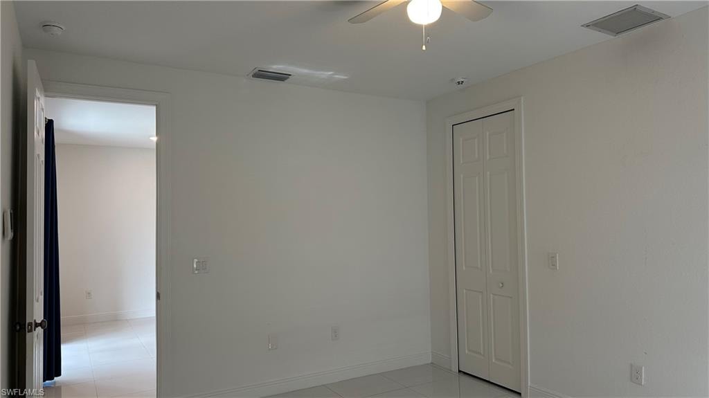 Spare room with light tile patterned floors and a ceiling fan