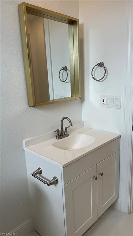 Bathroom with vanity and a textured wall