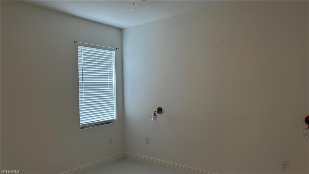 Unfurnished room featuring baseboards and light tile patterned floors