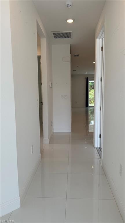Hall featuring recessed lighting and light tile patterned flooring