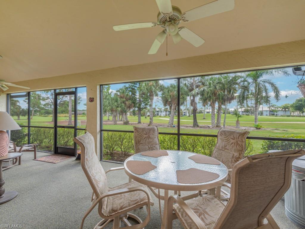 Sunroom featuring ceiling fan, view of golf course, and carpet floors