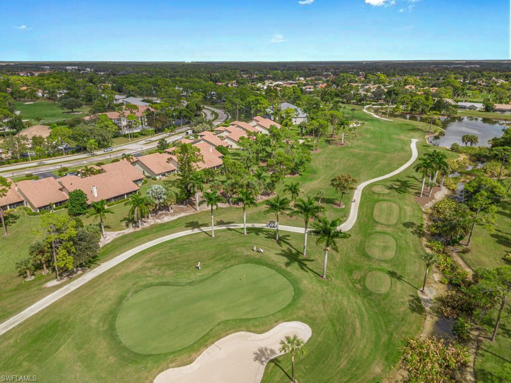 Aerial view of property's location featuring a local golf course and nearby suburban area