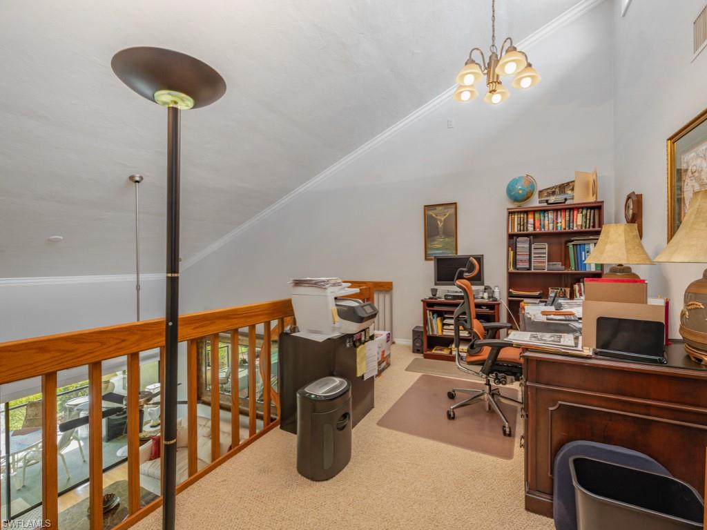 Office area with ornamental molding, carpet, a chandelier, and vaulted ceiling