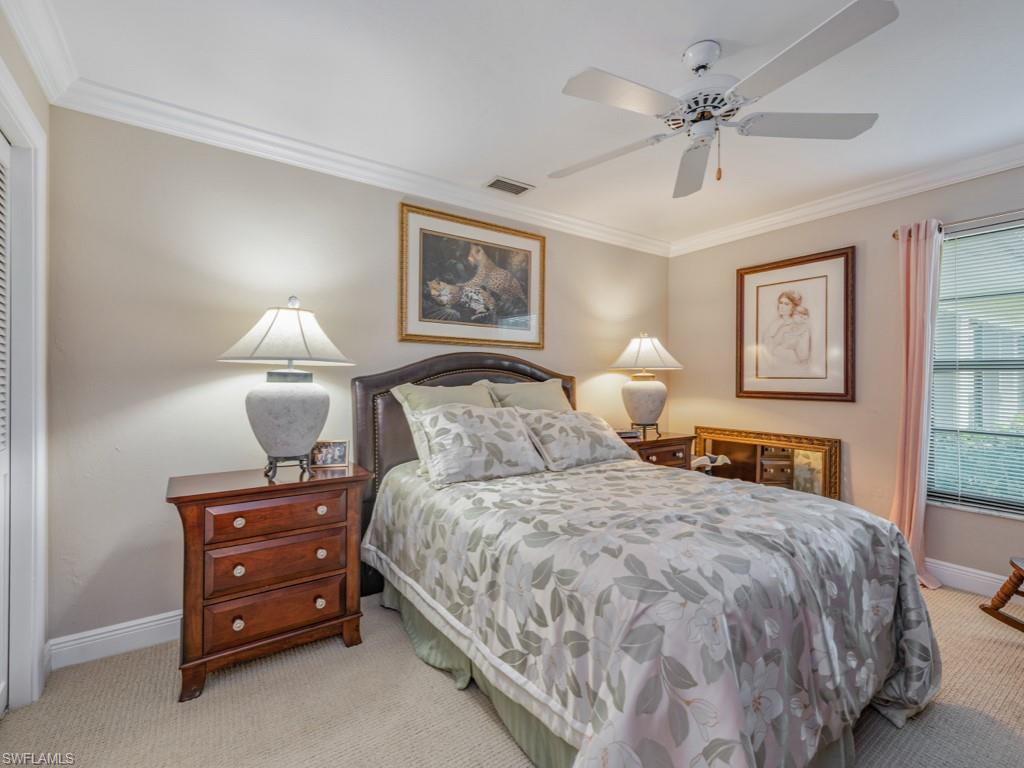 Carpeted bedroom with crown molding and a ceiling fan