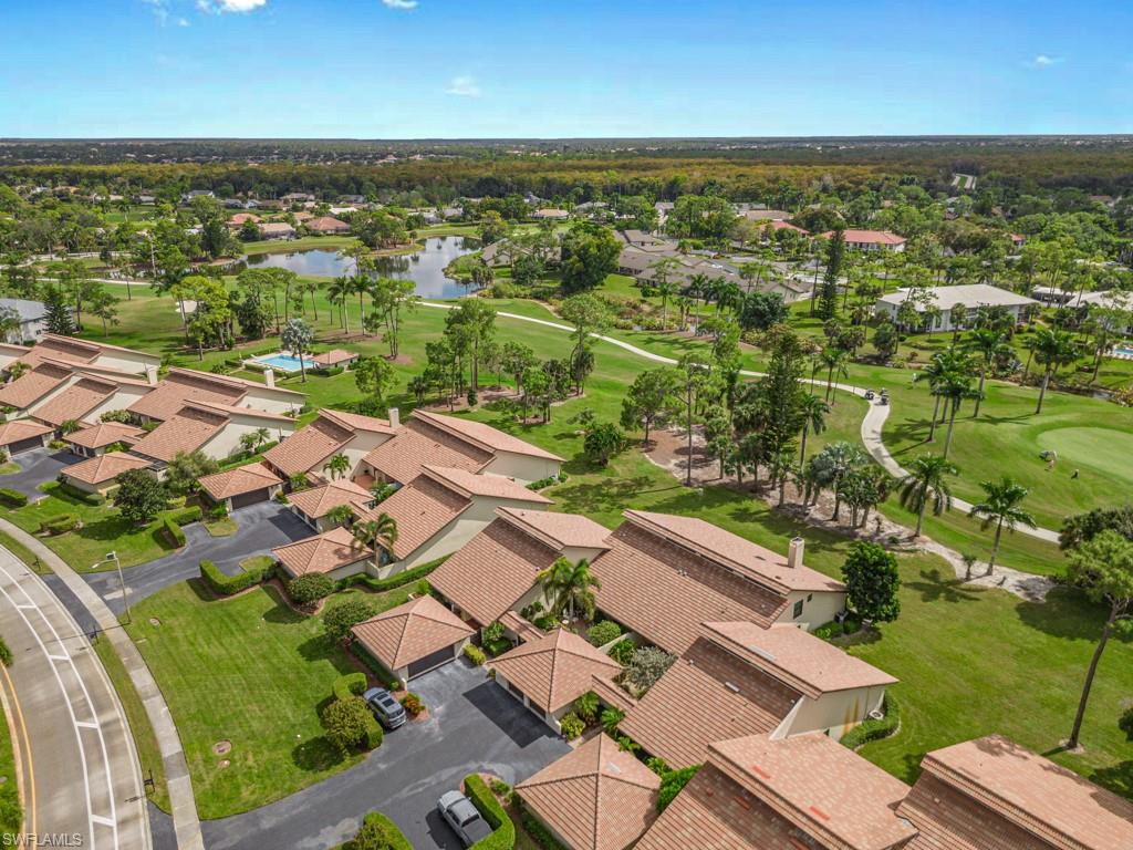 Aerial view of residential area with a golf club and a nearby body of water