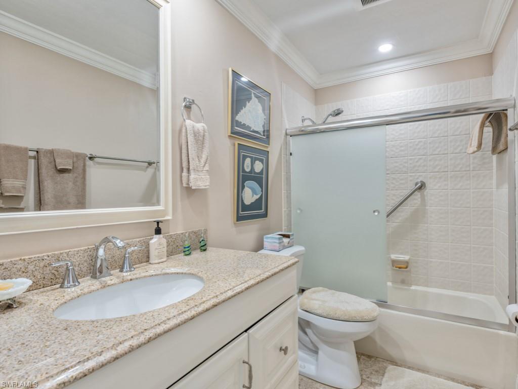 Bathroom featuring ornamental molding, vanity, and shower / bath combination with glass door