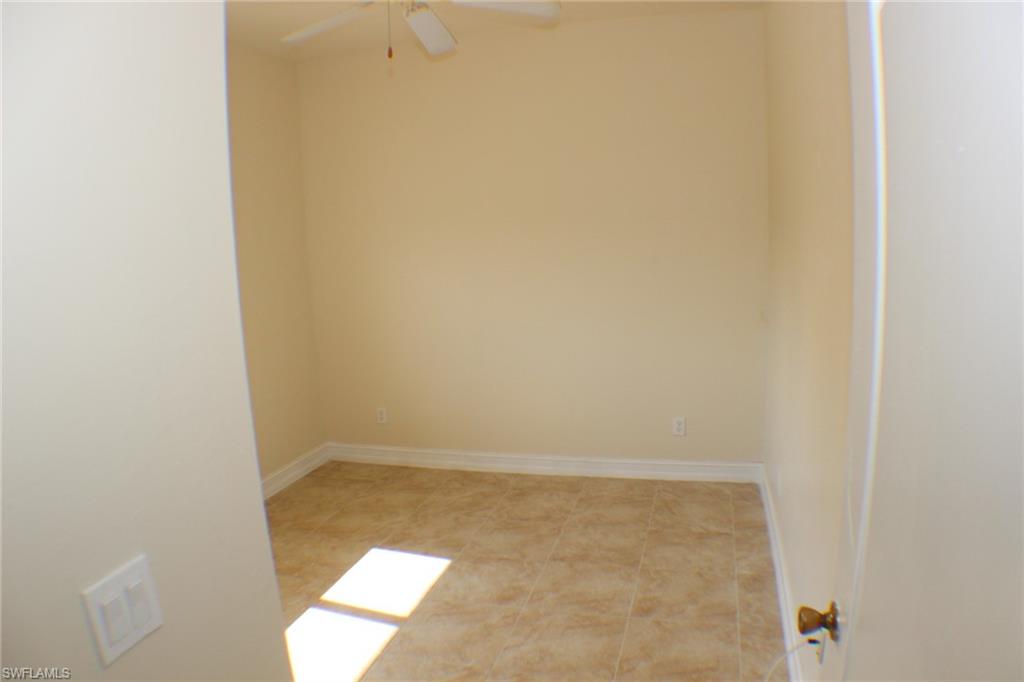 Spare room with ceiling fan and light tile patterned floors