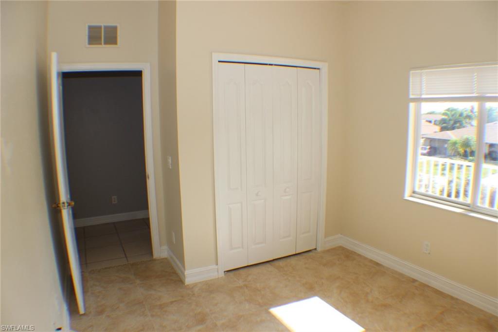 Unfurnished bedroom featuring a closet and light tile patterned floors