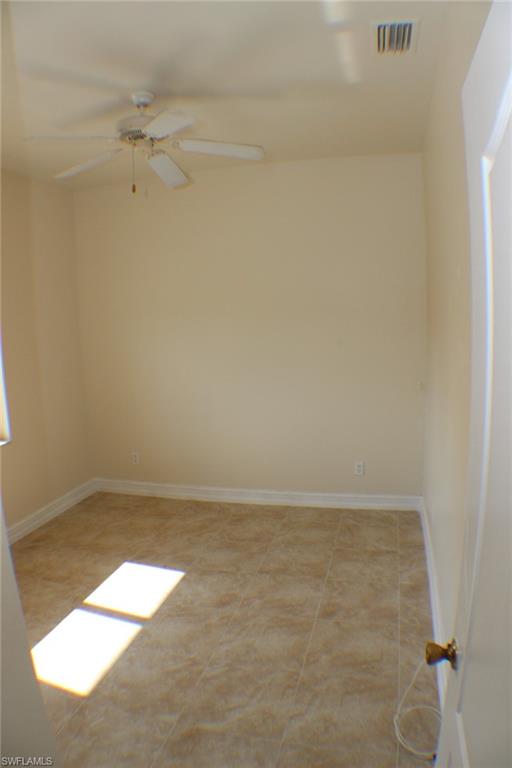 Unfurnished room featuring ceiling fan and light tile patterned floors