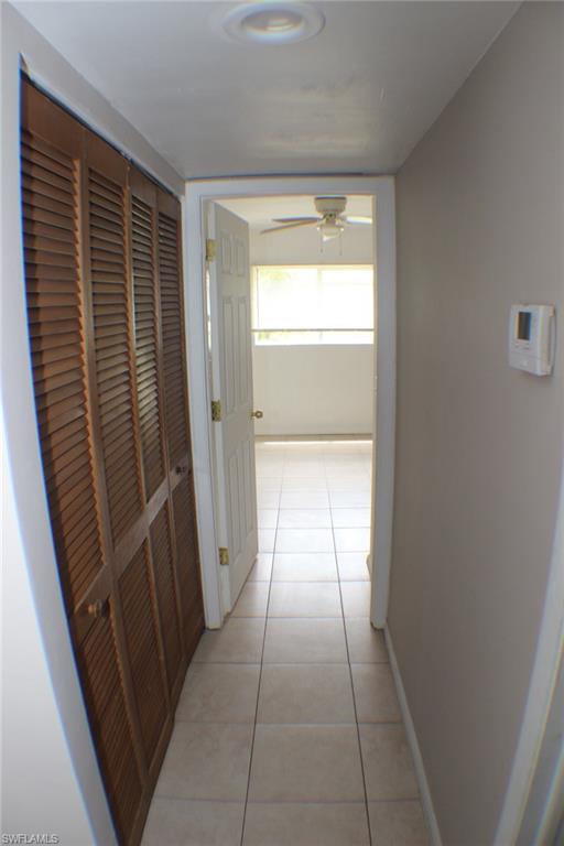 Hallway with light tile patterned floors and baseboards