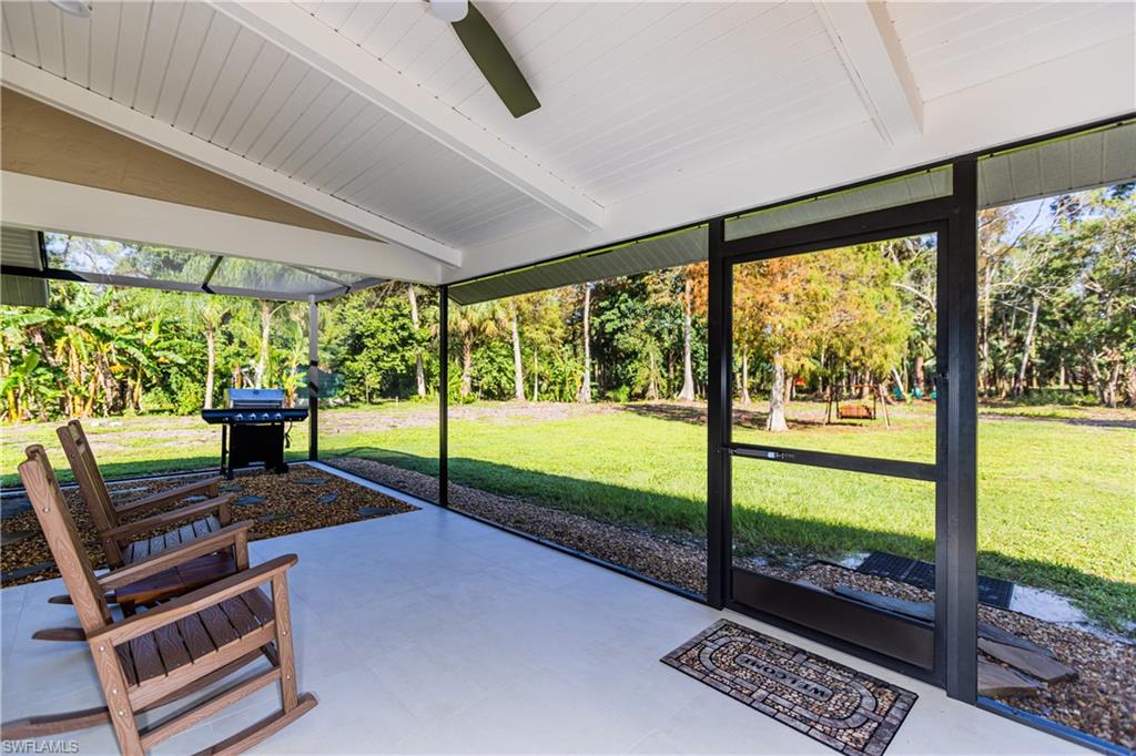 Sunroom featuring ceiling fan and a patio area