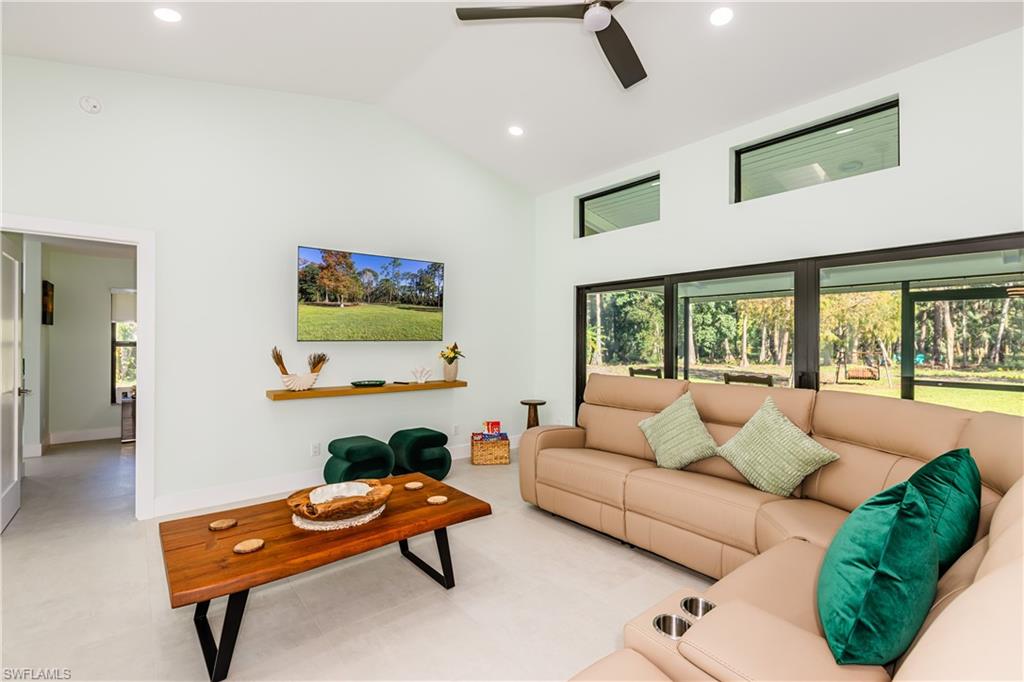 Living room featuring recessed lighting, high vaulted ceiling, and a ceiling fan