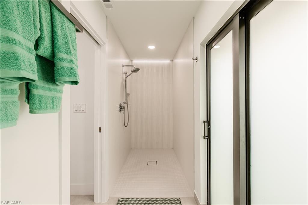 Bathroom featuring a shower stall, recessed lighting, and light tile patterned floors