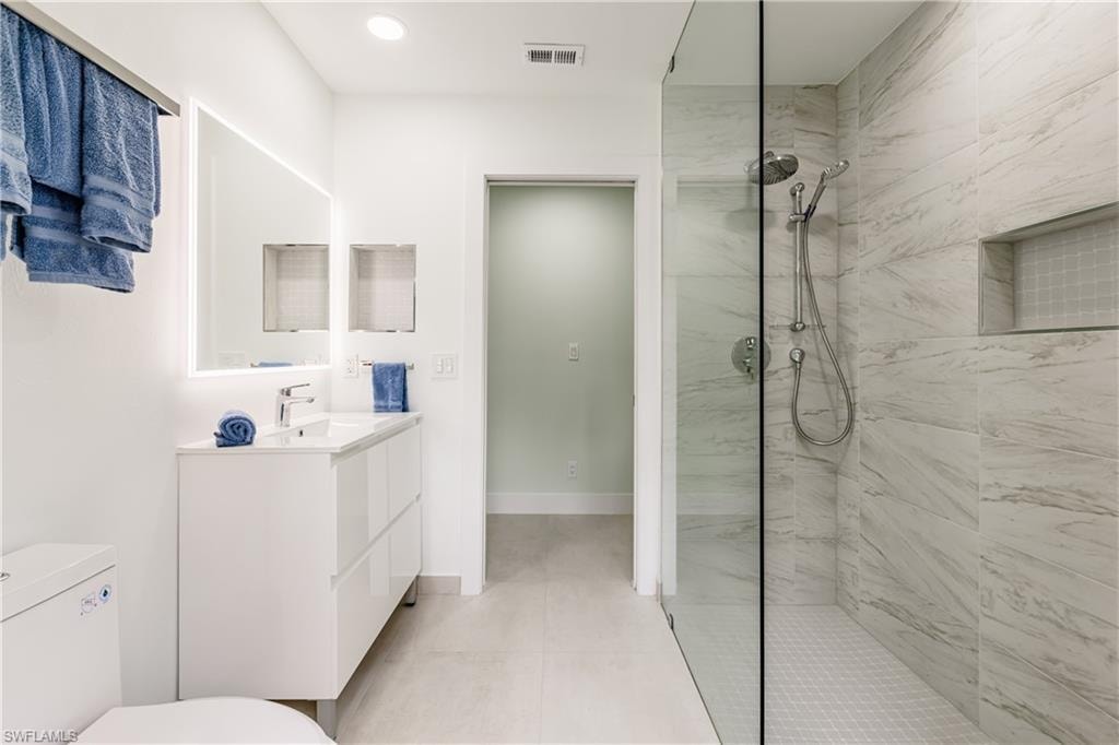 Full bathroom featuring walk in shower, vanity, recessed lighting, and access to outdoor area
