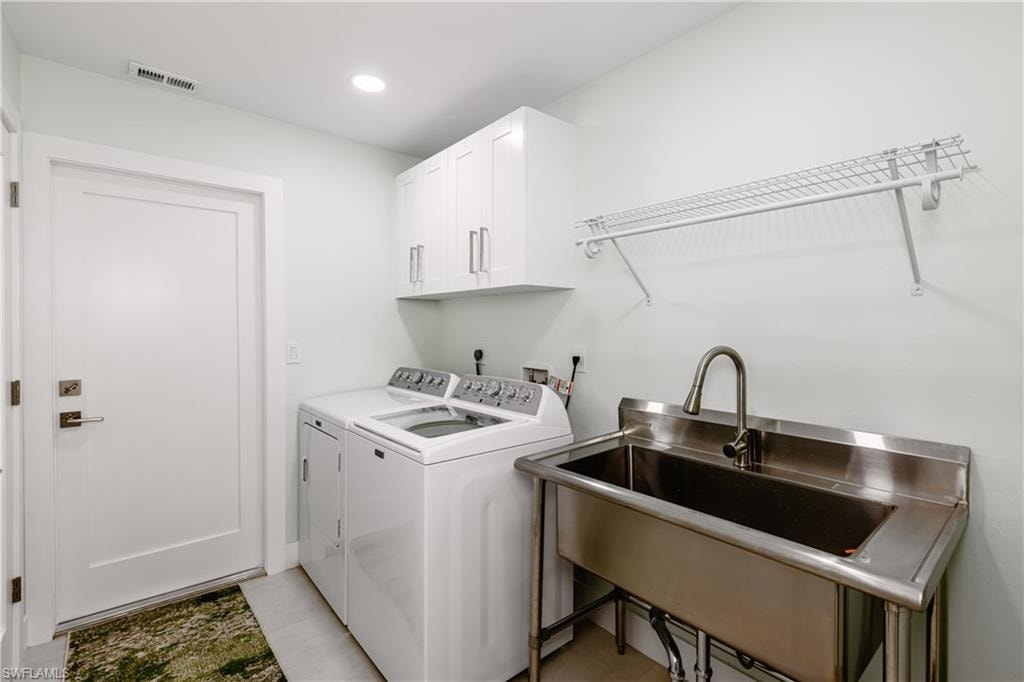 Laundry area with washer and dryer, cabinet space, and recessed lighting