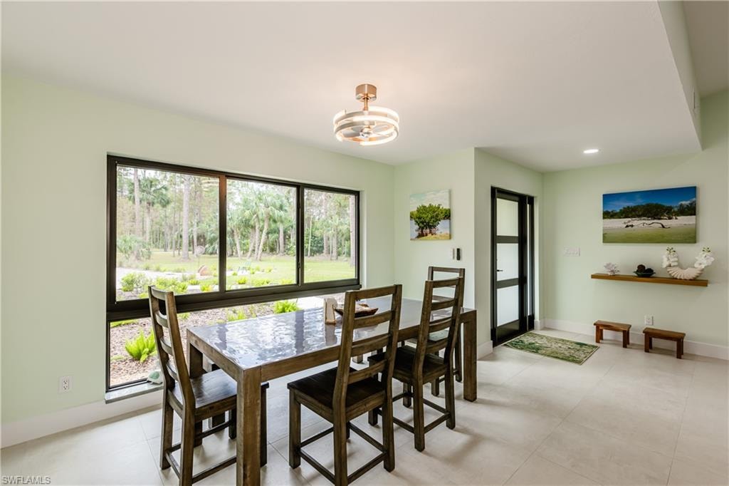 Dining area with light tile patterned floors, a chandelier, and recessed lighting