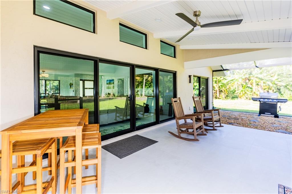 View of screened patio featuring a grill and ceiling fan