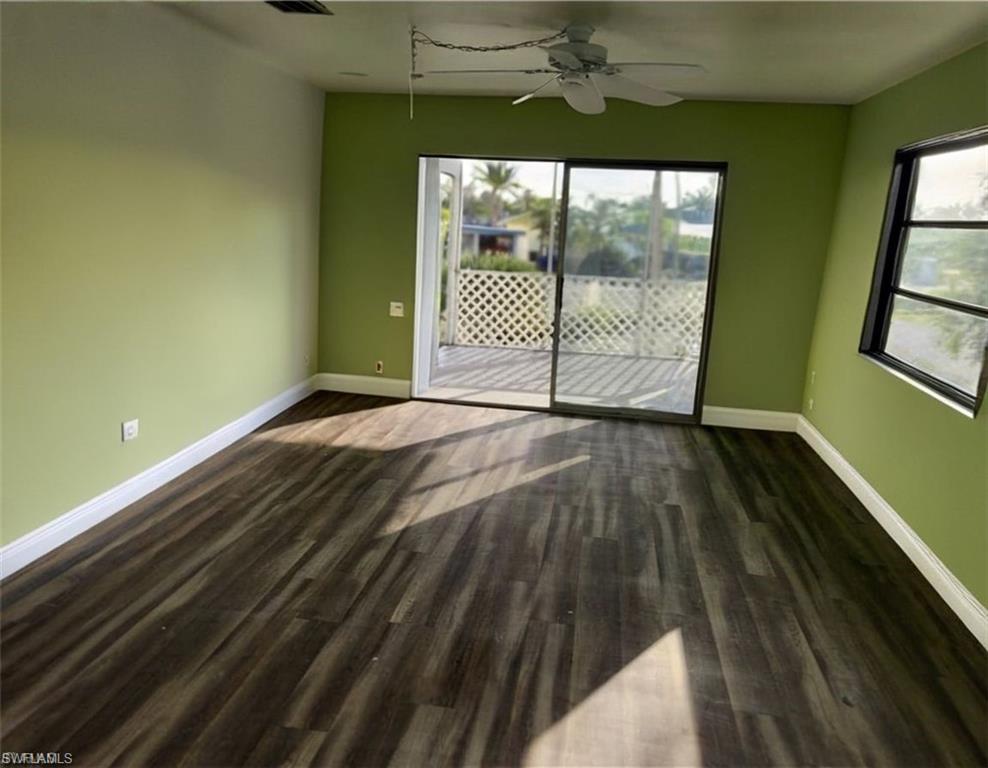 Living room featuring dark hardwood / wood-style flooring and ceiling fan VIRTUALLY EDITED